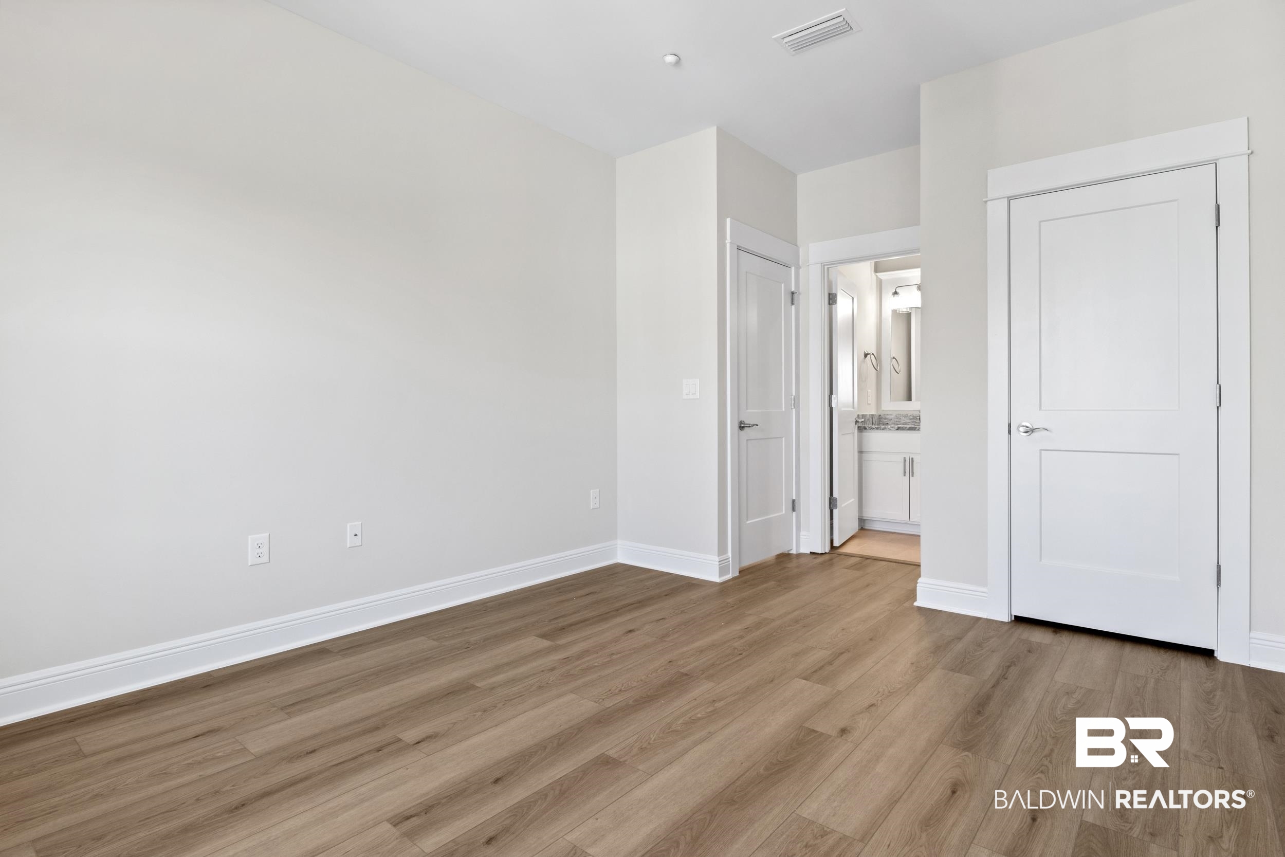 2847 Salt Drive Orange Beach, AL 36561 - Photo 21 of 29 Unfurnished bedroom with connected bathroom and light hardwood / wood-style floors
