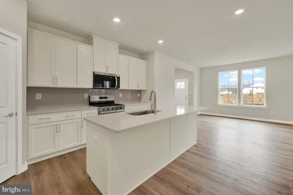 a kitchen with a stove a sink and a microwave