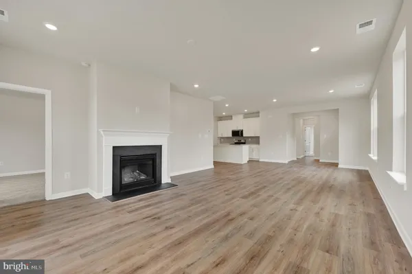 a view of empty room with wooden floor and a fireplace