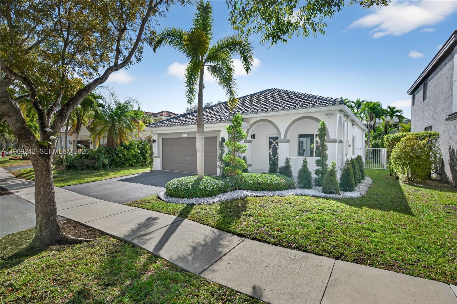 a front view of a house with a yard and potted plants