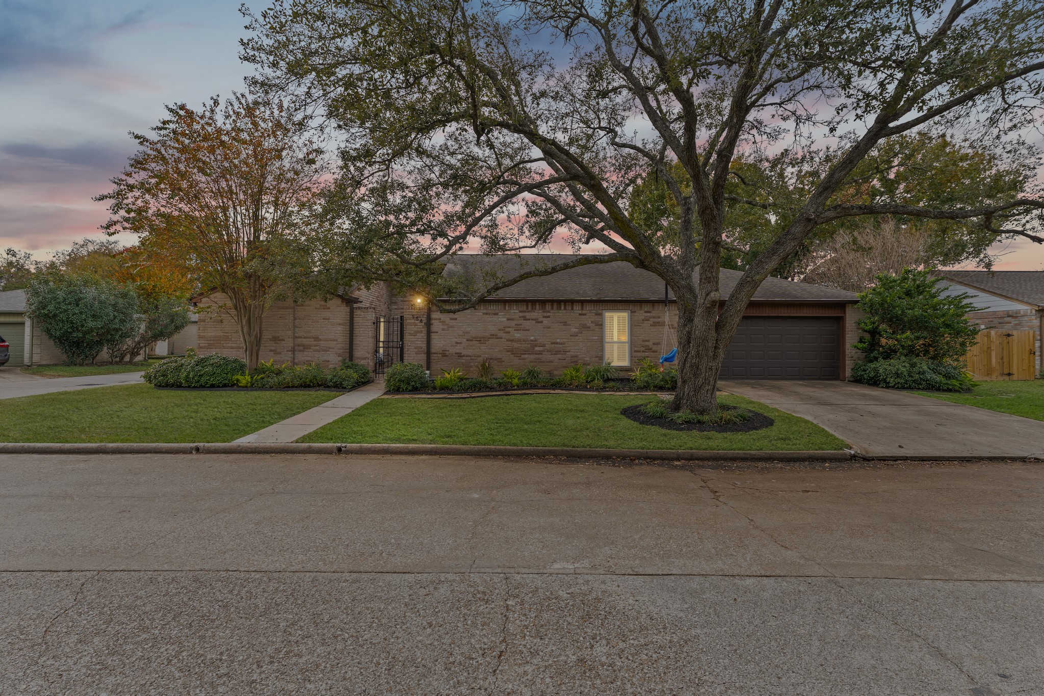 a view of a house with a big yard and large trees