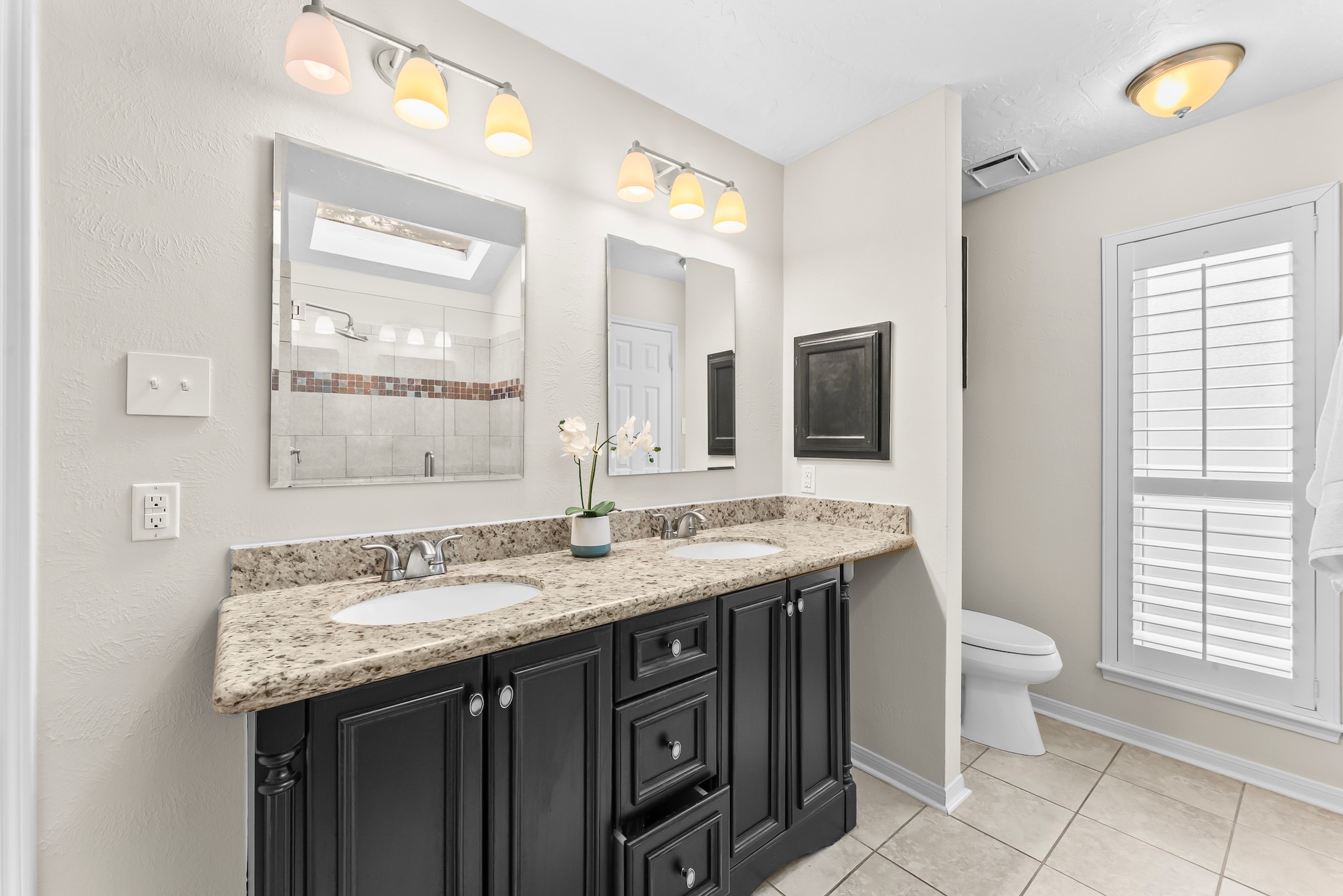 1546 Beaconshire Houston, TX 77077 - Photo 20 of 29 a bathroom with a granite countertop sink a toilet and a mirror