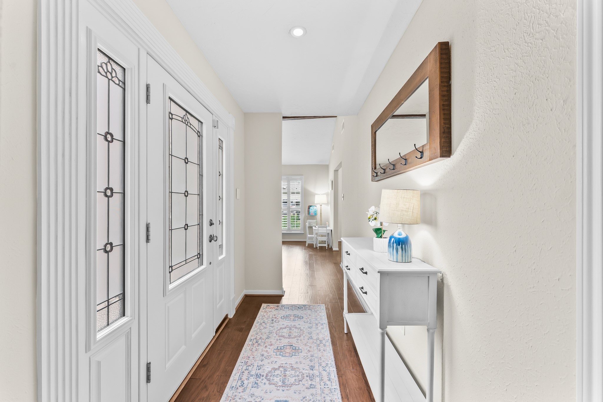 1546 Beaconshire Houston, TX 77077 - Photo 4 of 29 a hallway with white cabinets and wooden floor