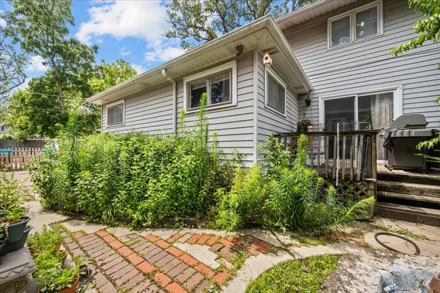 a backyard of a house with table and chairs and potted plants