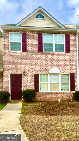 a view of a brick house with a yard