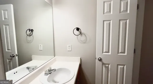 a bathroom with a granite countertop sink toilet and mirror