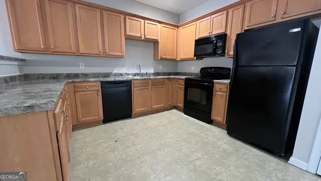 a kitchen with stainless steel appliances granite countertop a refrigerator stove top oven a sink and dishwasher