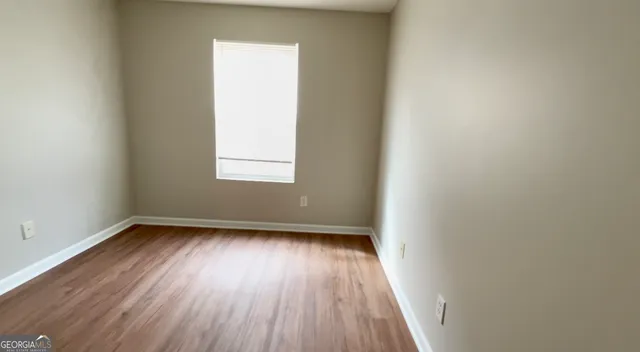 a view of a room with wooden floors and window