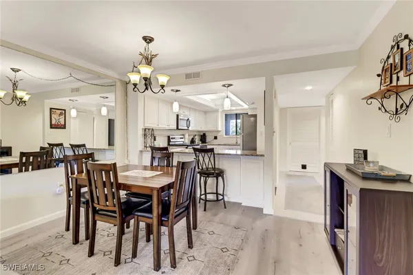 a view of a dining room with furniture and chandelier