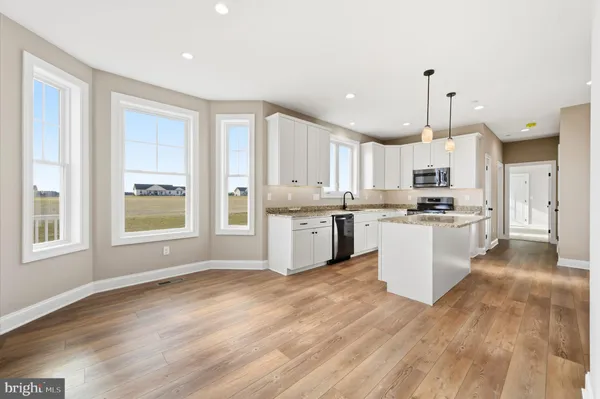 a large kitchen with cabinets and wooden floor
