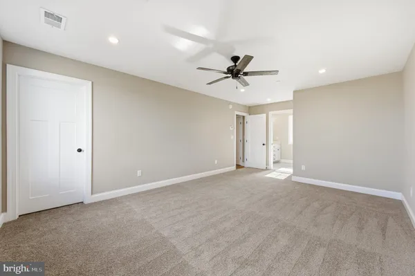 a view of an empty room with a ceiling fan