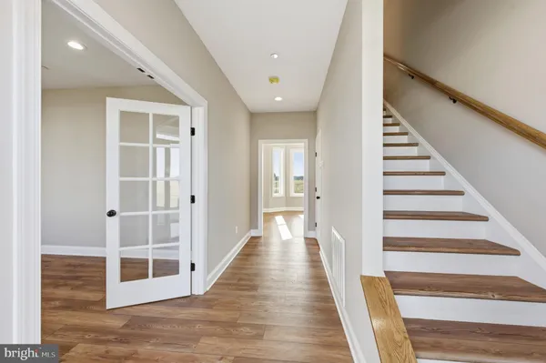 a view of a hallway with wooden floor and entryway