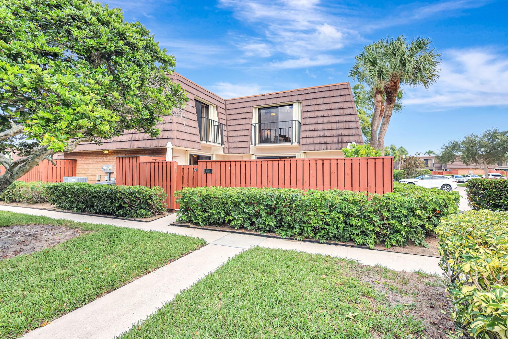 2332 23rd Court, Unit 57D Jupiter, FL 33477 - Photo 2 of 53 a front view of a house with a yard