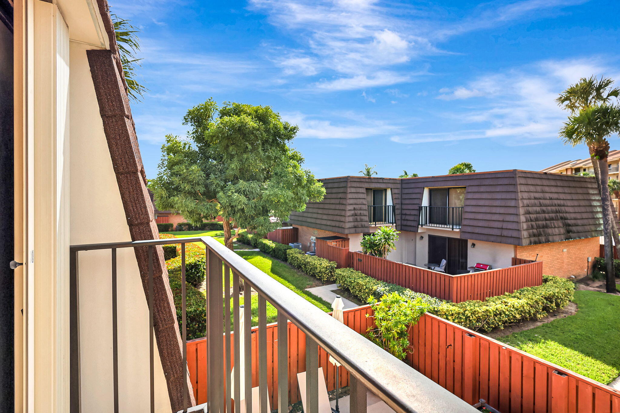 2332 23rd Court, Unit 57D Jupiter, FL 33477 - Photo 26 of 53 a view of balcony with wooden floor and fence