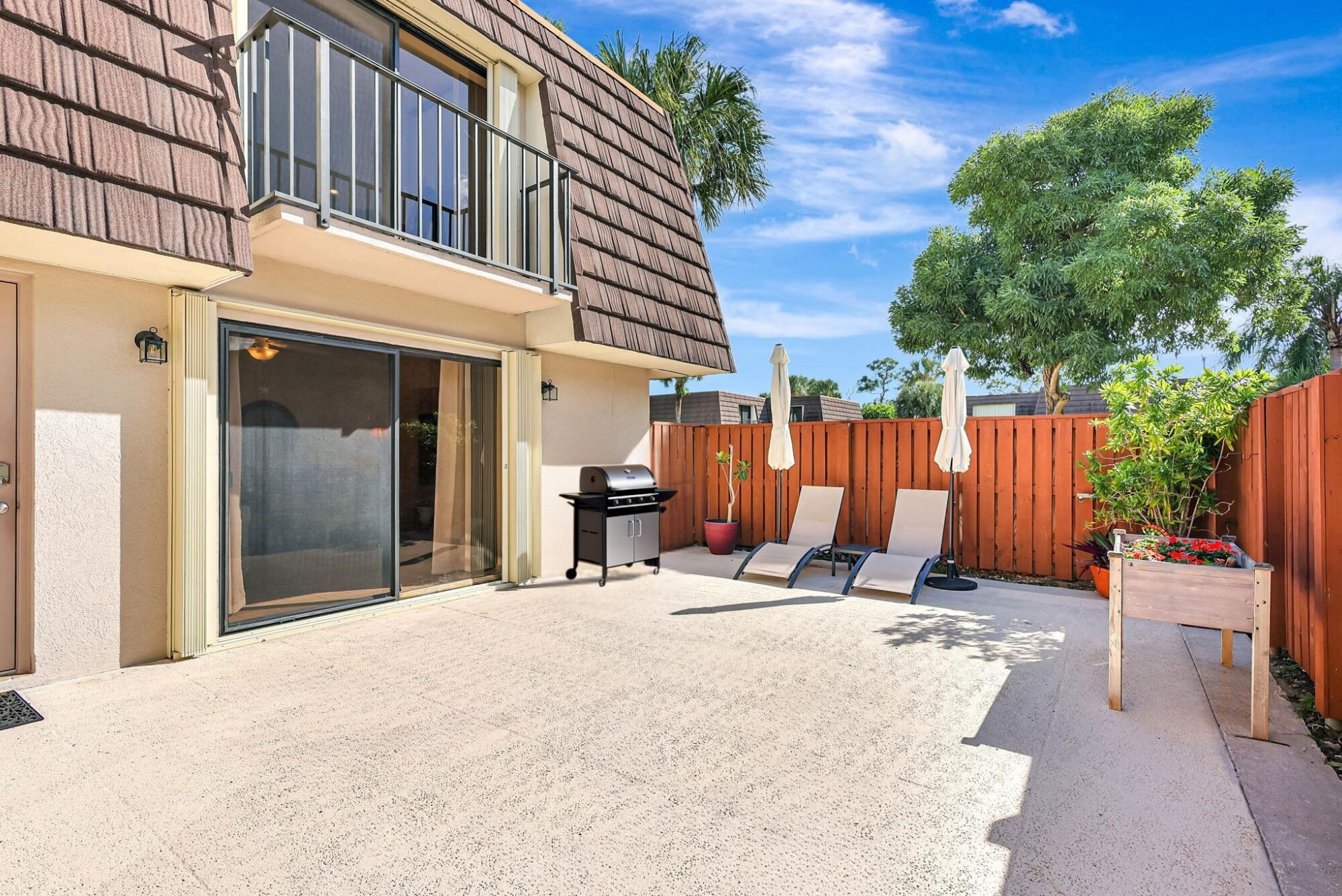 2332 23rd Court, Unit 57D Jupiter, FL 33477 - Photo 3 of 53 a view of a patio with a table and chairs and potted plants