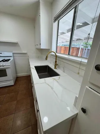 a kitchen with a stove and white cabinets