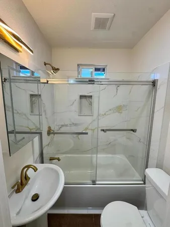a bathroom with a sink toilet and shower