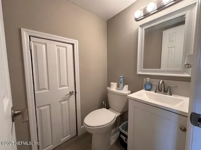 a bathroom with a toilet sink vanity and mirror