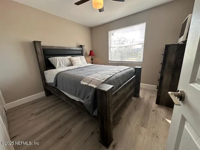 a bedroom with a bed and a flat tv screen on the dresser