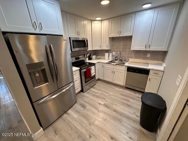 a kitchen with a refrigerator a stove top oven a sink and dishwasher