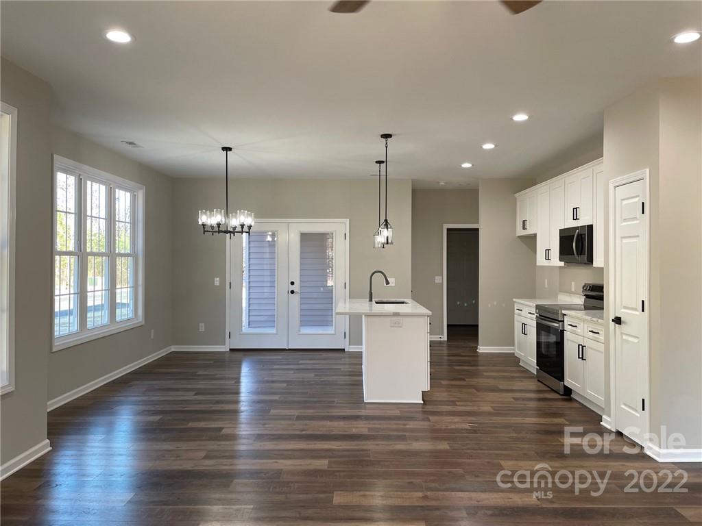 152 Eagles Landing Morganton, NC 28655 - Photo 6 of 27 a open kitchen with stainless steel appliances granite countertop a stove a sink dishwasher a refrigerator and white cabinets with wooden floor