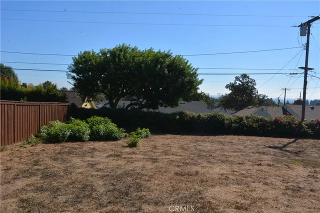 a view of backyard with wooden fence