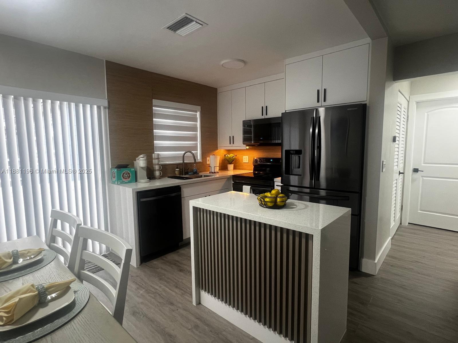 222 Southwest 8th Street, Unit A Dania Beach, FL 33004 - Photo 3 of 16 a room with a window a wooden floor and a view of bedroom