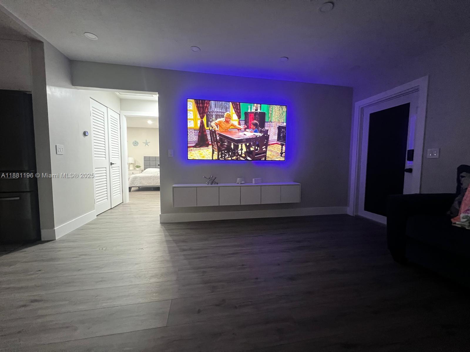 222 Southwest 8th Street, Unit A Dania Beach, FL 33004 - Photo 6 of 16 an empty room with wooden floor and windows