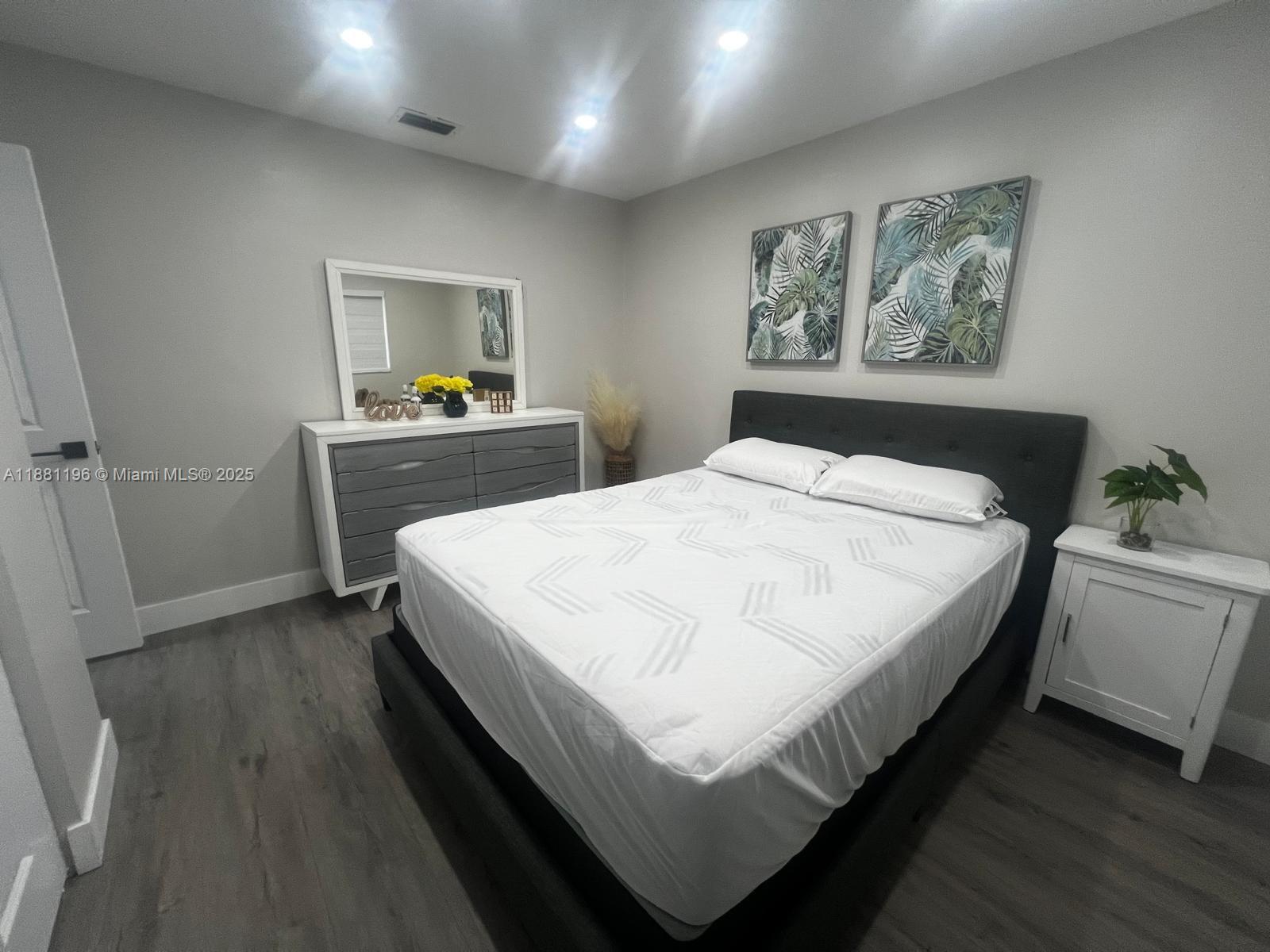 222 Southwest 8th Street, Unit A Dania Beach, FL 33004 - Photo 7 of 16 a bedroom with a bed and a painting on the wall