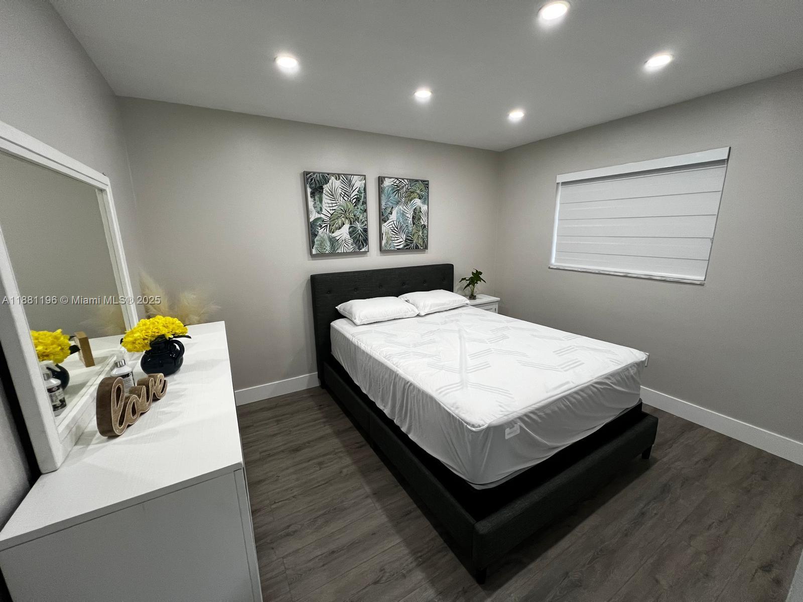 222 Southwest 8th Street, Unit A Dania Beach, FL 33004 - Photo 8 of 16 a bed sitting in a room next to a window