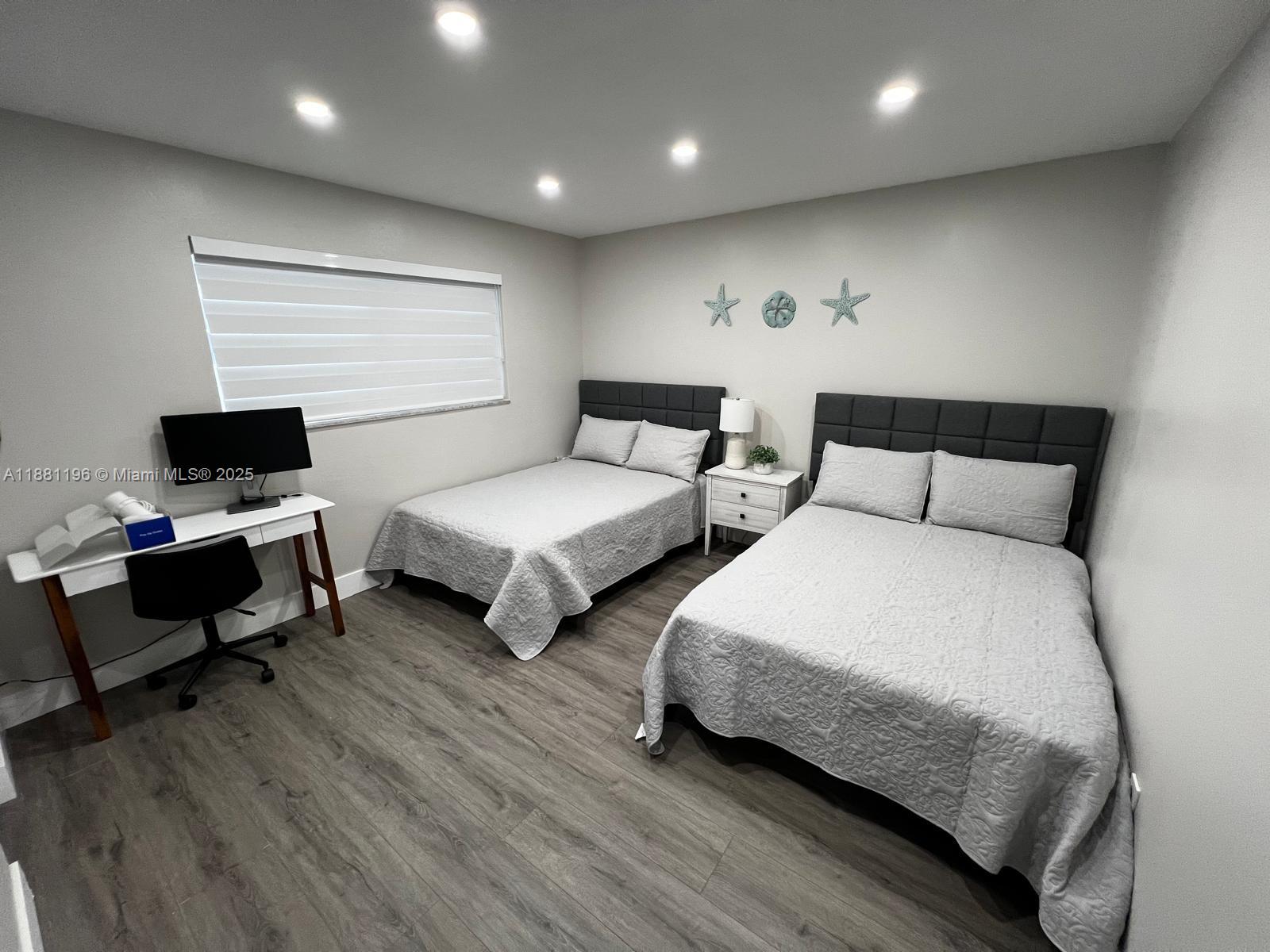 222 Southwest 8th Street, Unit A Dania Beach, FL 33004 - Photo 10 of 16 a bedroom with two beds and a desk