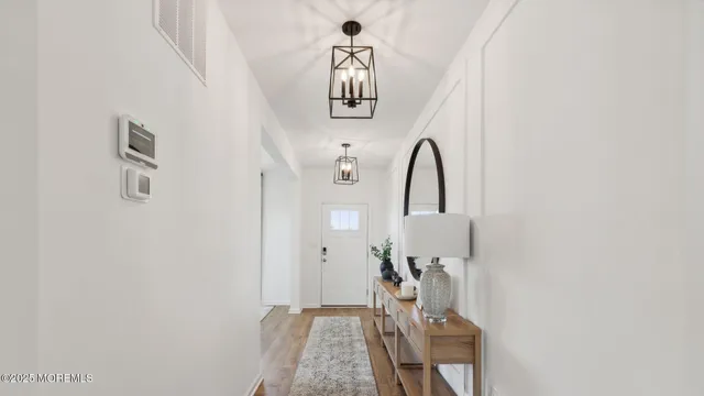 a room with stainless steel appliances kitchen island granite countertop furniture a sink a rug and a wooden floor