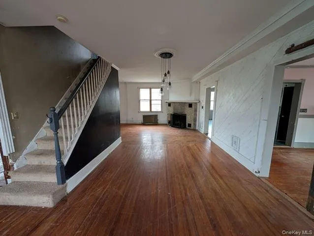 a view of a hallway with wooden floor and stairs