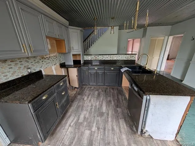 a kitchen with granite countertop a sink stove and refrigerator