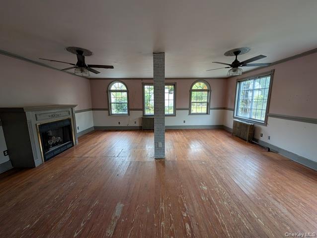 398 Angola Road Cornwall, NY 12518 - Photo 6 of 12 an empty room with wooden floor a chandelier a fireplace and windows