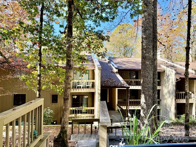 a front view of a house with glass windows and furniture