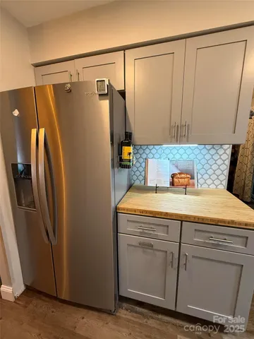 a bathroom with a granite countertop sink and a refrigerator