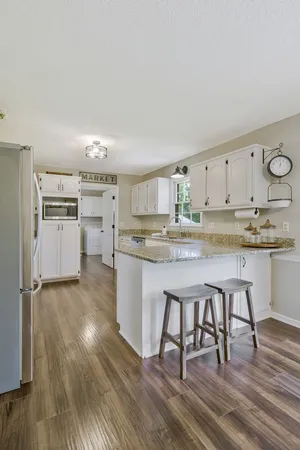 a kitchen with stainless steel appliances a stove a sink cabinets and wooden floor