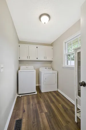 a utility room with cabinets washer and dryer