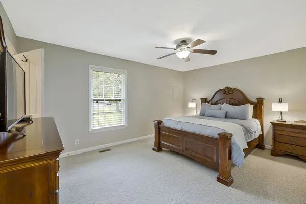 a bedroom with a bed and a ceiling fan