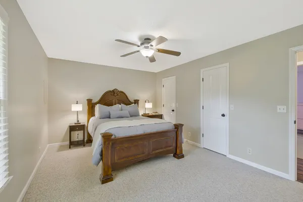 a spacious bedroom with a bed and a ceiling fan