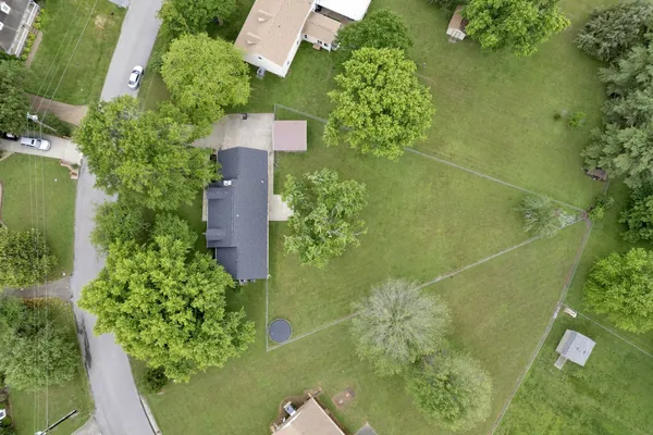 an aerial view of a residential houses with yard