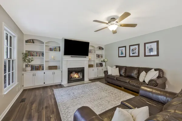 a living room with furniture a fireplace and a flat screen tv