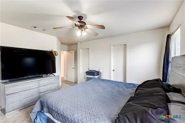 a bedroom with a bed and a flat screen tv