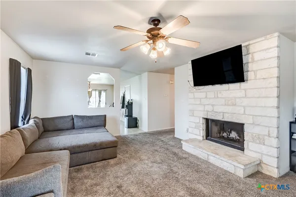 a living room with furniture a flat screen tv and a fireplace