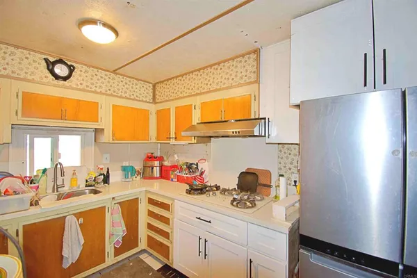 a kitchen with stainless steel appliances a stove a refrigerator and a sink