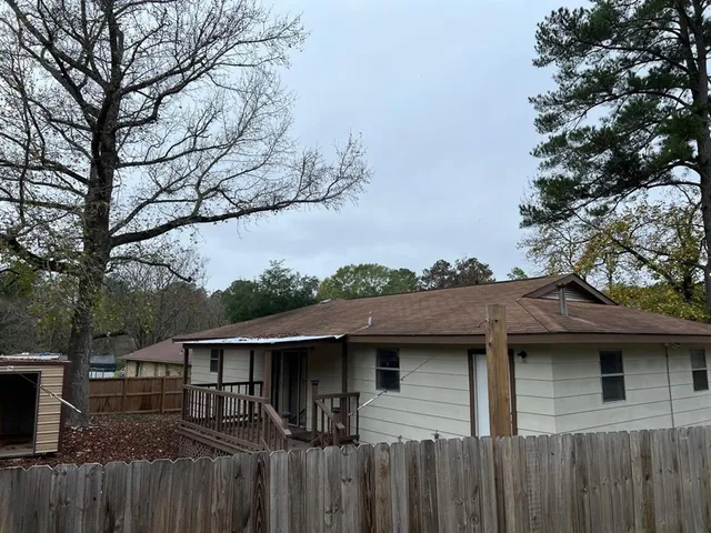 a side view of a house with a wooden fence