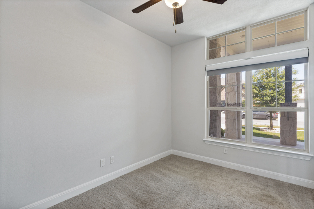 727 Spinnaker Loop Kyle, TX 78640 - Photo 23 of 29 Plush carpeting and towering multi-pane windows with transoms define this versatile space.