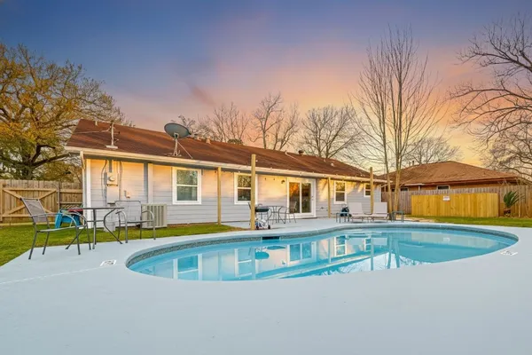 a view of a house with pool and chairs