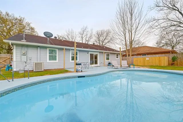 a view of house with swimming pool yard and outdoor seating